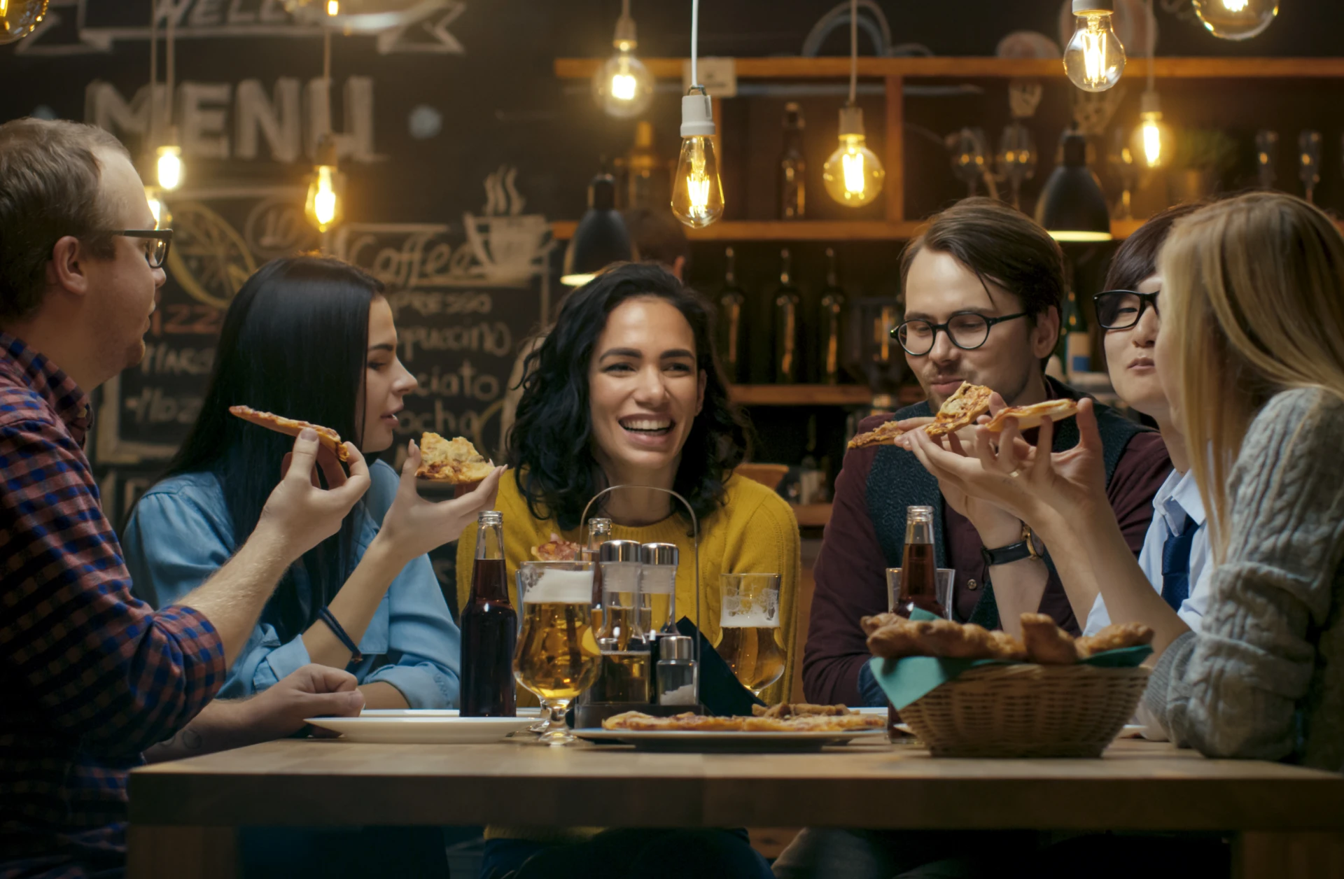 Group laughing and eating pizza together